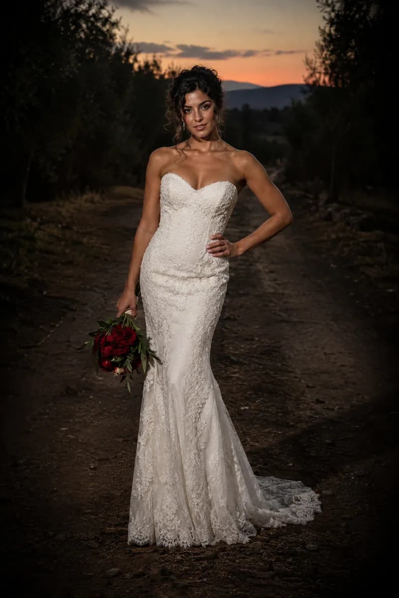Ilustración creada con IA: novia con vestido columna en un camino oscuro, mano en la cadera y ramo colgando