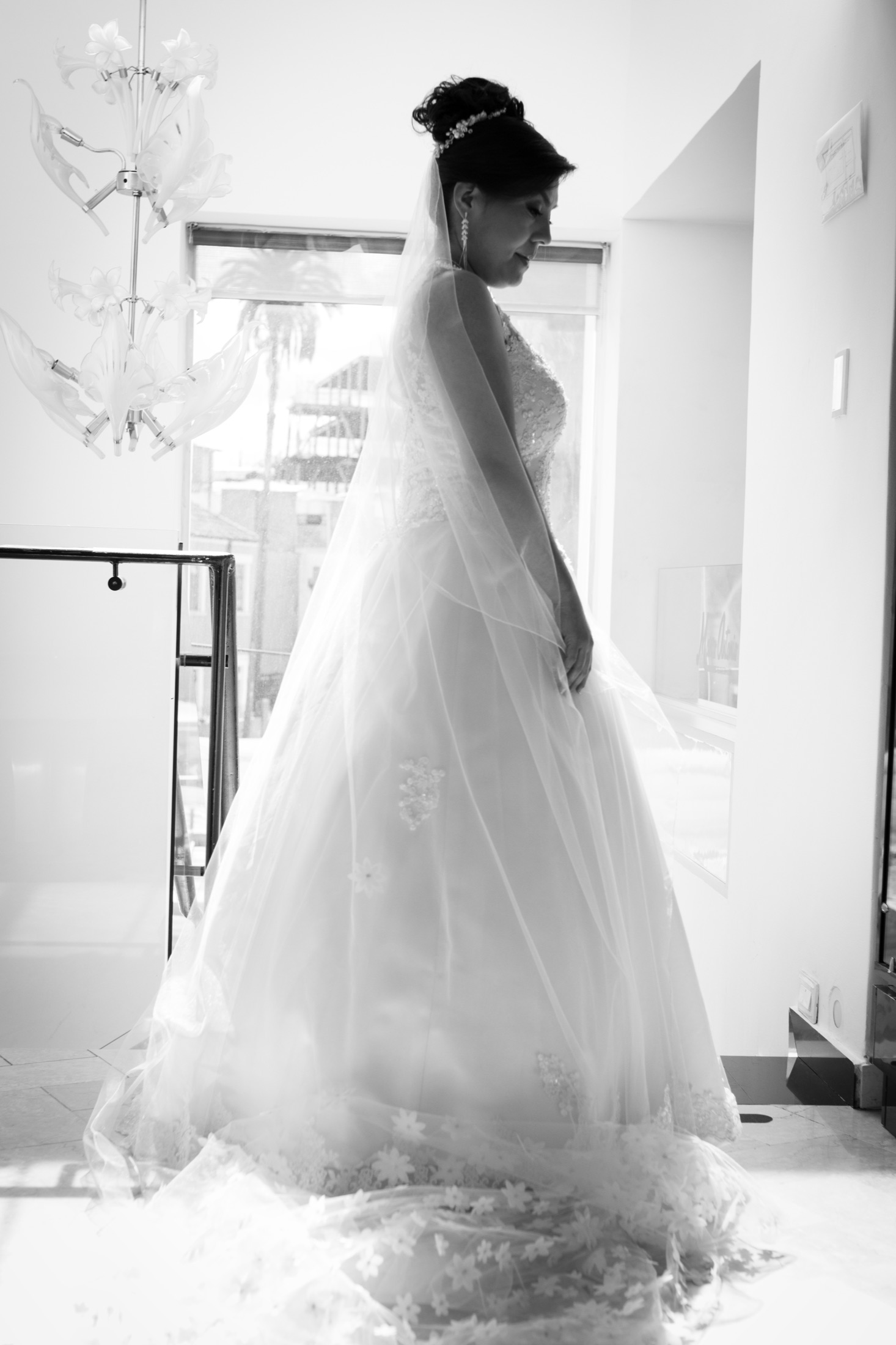Novia de perfil a contraluz junto a una ventana, en blanco y negro