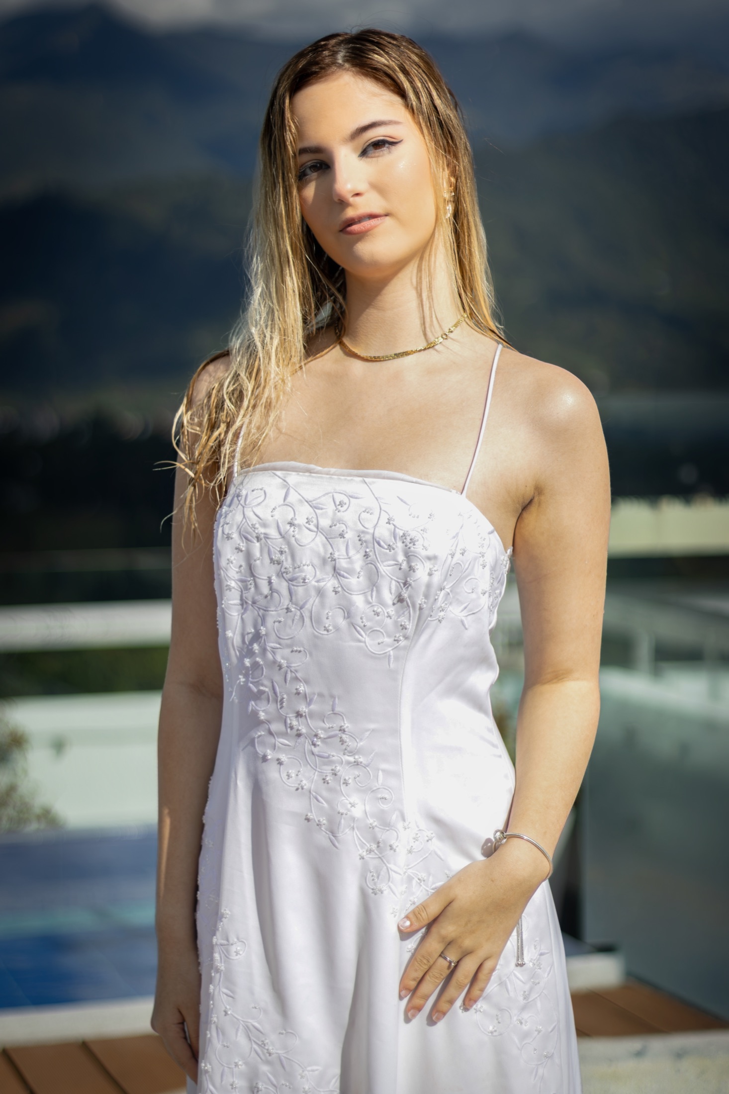 Retrato frontal de la novia con el cabello mojado y vista a las montañas