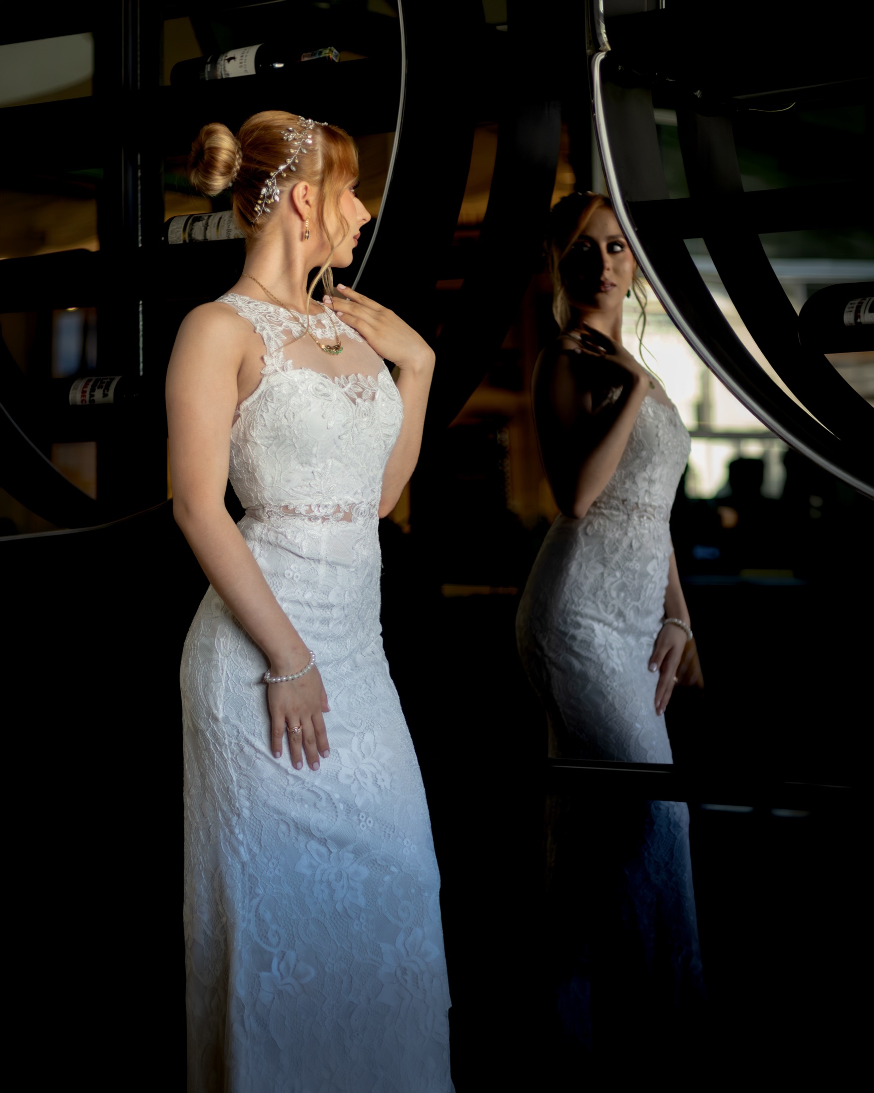 Novia reflejada en un espejo circular durante los preparativos
