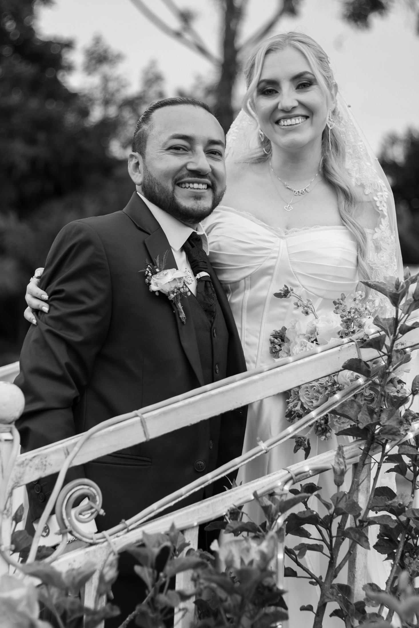 Novios abrazados riendo en el jardín