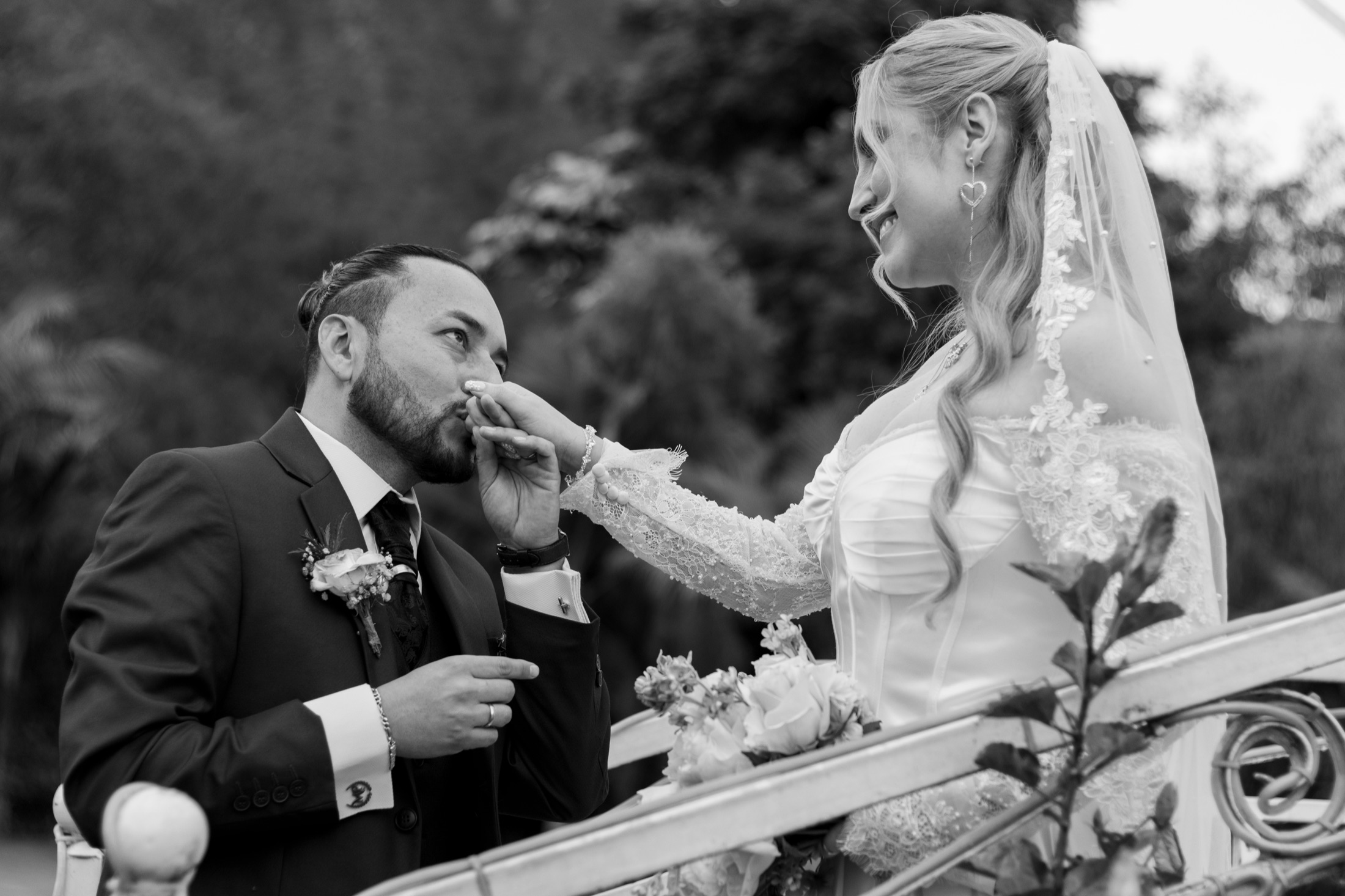 Novios besándose sobre un carruaje decorado para la boda