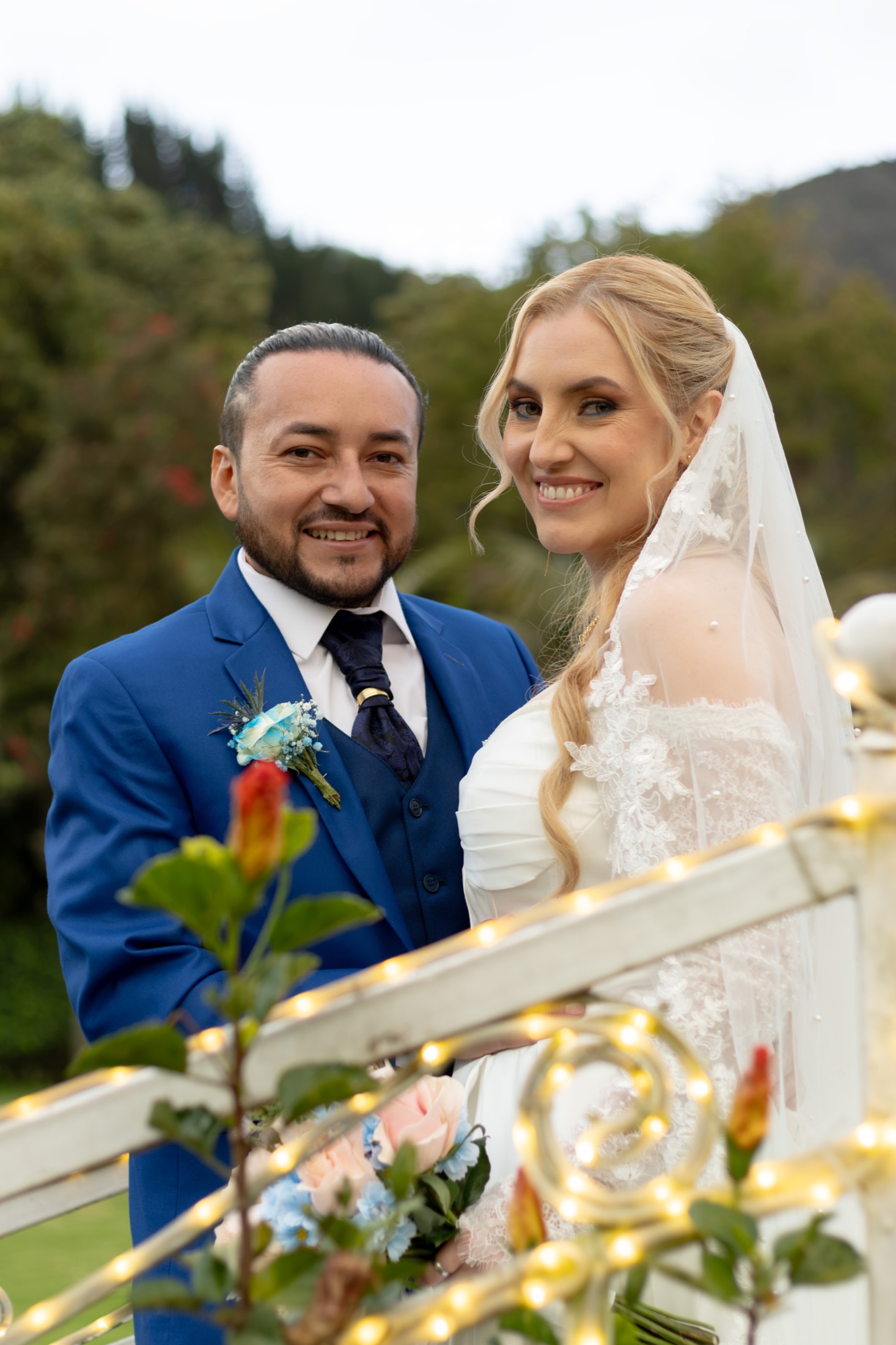Pareja de novios caminando tomados de la mano por el jardín