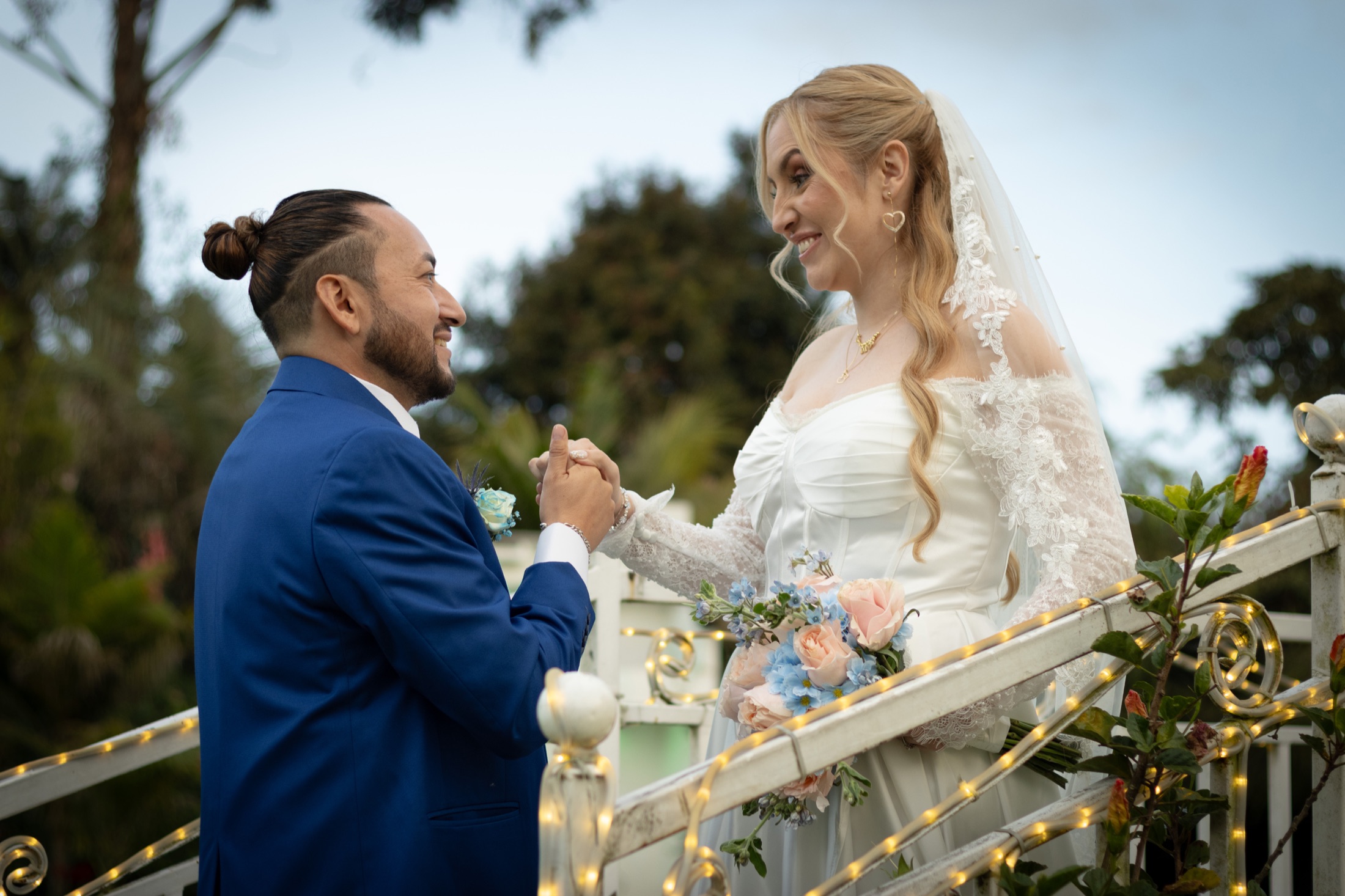 Pareja de novios mirándose con complicidad al aire libre