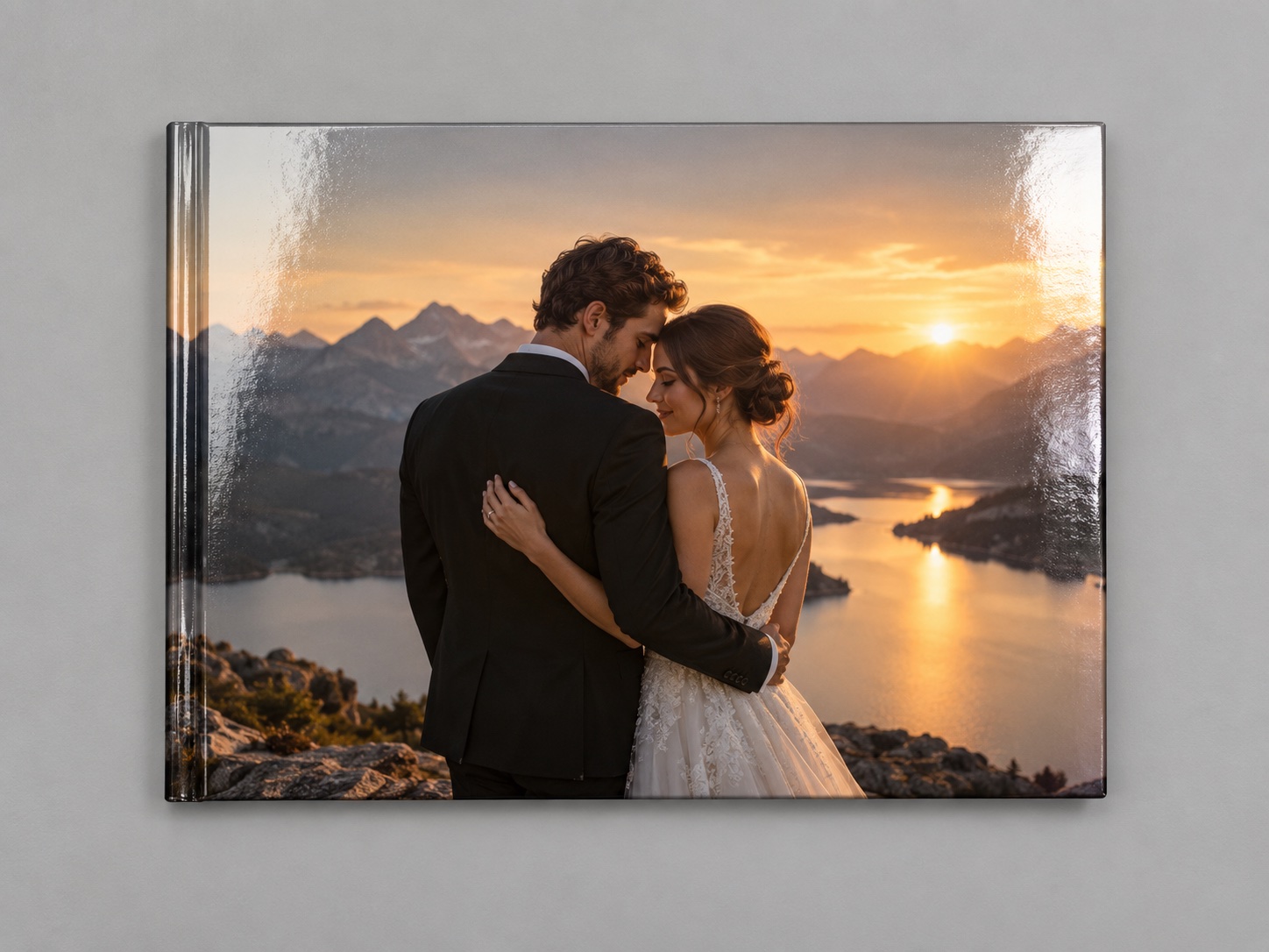 Portada brillante del PhotoBook Premium apoyada en una superficie con foto de boda al atardecer